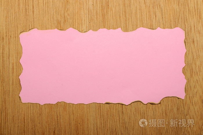 粉红色的烧过的纸木制背景上