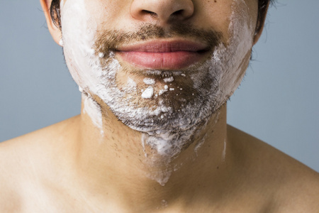年轻男人下巴覆盖在剃须泡沫图片