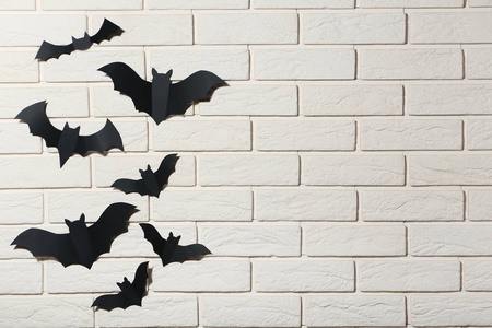 万圣节纸蝙蝠在白色砖墙背景