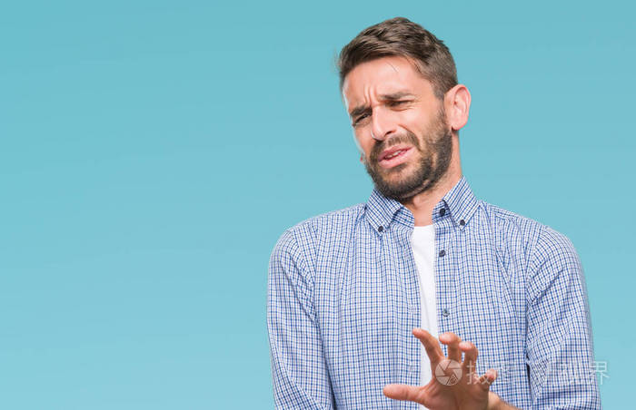 年轻英俊的男子穿着白色 t恤在孤立的背景下反感的表情, 不高兴和害怕