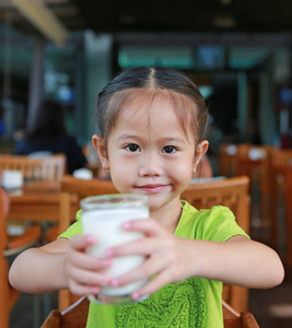 小亚洲女孩早上在餐厅喝牛奶