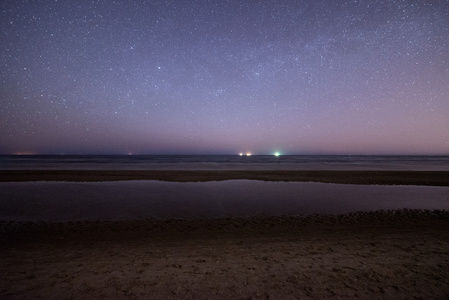 在海滩上的星星的夜空.空间视图照片