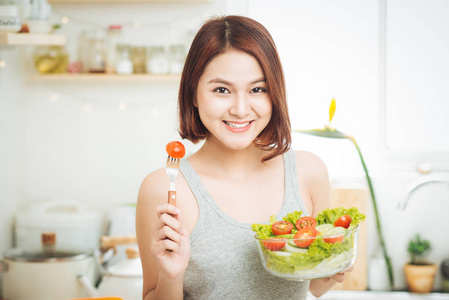 美丽的亚洲妇女吃新鲜蔬菜沙拉。松动重量概念