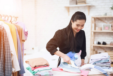 小亚细亚女佣在更衣室熨衣服