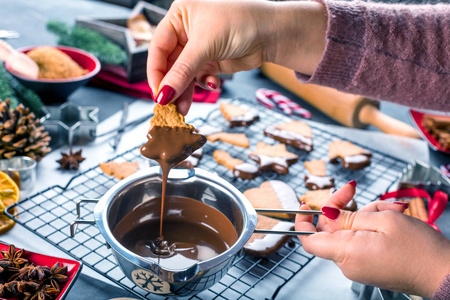 妇女在厨房桌上用液态巧克力上光圣诞饼干