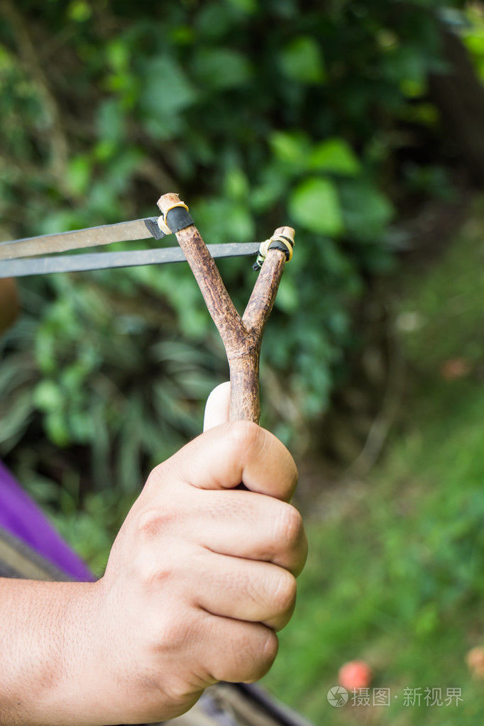 手里拿着弹弓绿色背景