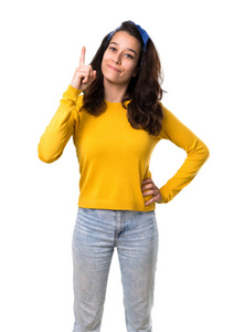 年轻女孩与黄色毛衣和蓝色头巾在她的头上显示和举起手指在查出的白色背景最好的标志