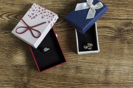 婚礼色系红蓝金戒指躺在木桌上的红蓝盒子里照片