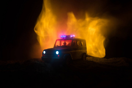 警车在夜间追着雾背景的汽车。911紧急反应警车超速驶向犯罪现场。选择性焦点