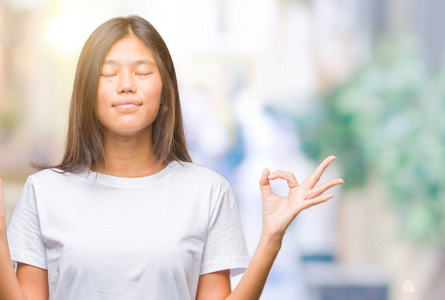 在孤立的背景下, 年轻的亚洲妇女放松和微笑闭上眼睛做冥想手势用手指。瑜伽理念