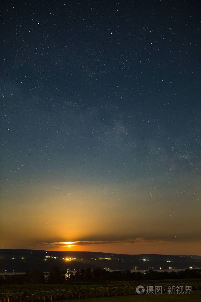 月亮升起在葡萄园和湖下的恒星和银河