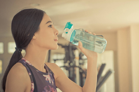 妇女在健身健身房喝淡水