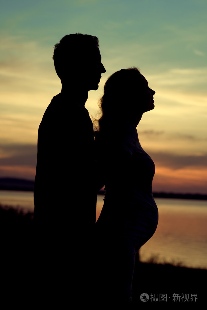 那个拥抱他怀孕的妻子的剪影