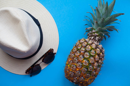 夏季沙滩配件。草帽, 太阳镜, 菠萝。夏天。明亮。黄色背景。热