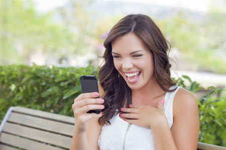 微笑年轻成年女性发短信在手机户外