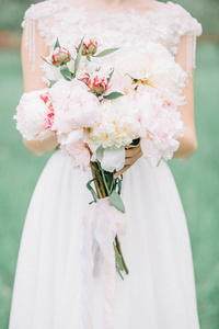 美丽婚礼花束粉红色和白色牡丹花在新娘的手中