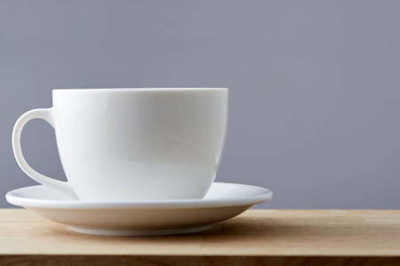 选择性聚焦侧特写视图白色茶杯和飞碟在灰色背景下分离