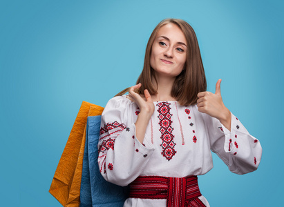 女孩在乌克兰民族服饰和购物袋图片
