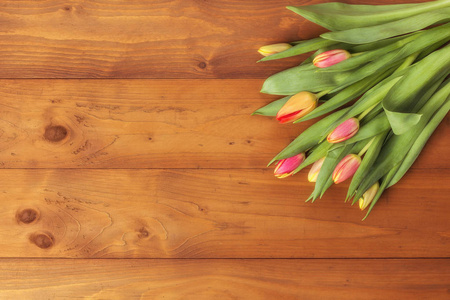 在木质背景的郁金香花束。春天的花朵。母亲节背景