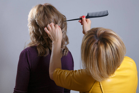 女人的发型.理发师梳头的客户.后视图.水平框架射击照片