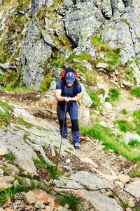 年轻男子徒步艰难山路与挂电缆