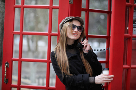 一个电话亭里漂亮的年轻女孩女孩在谈论