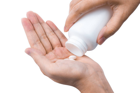 成年女子手把药片从白色塑料瓶中取出, 她的手被白色的背景所隔离。成人保健