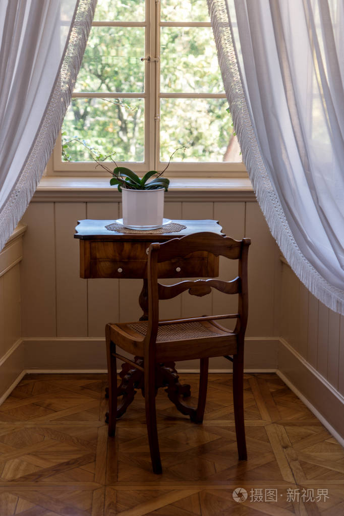 老式房间,窗前有桌子和椅子.