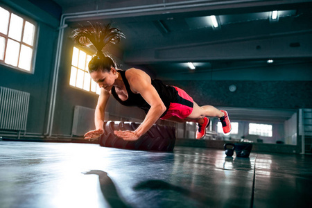 强壮有力的女人做艰苦的剧烈 crossfit 锻炼在健身房, 飞行俯卧撑