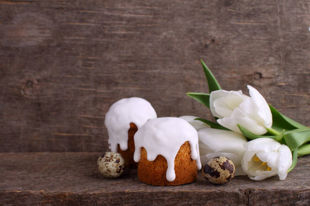 复活节作文与新鲜的白色郁金香, 鹌鹑蛋和复活节蛋糕在木背景