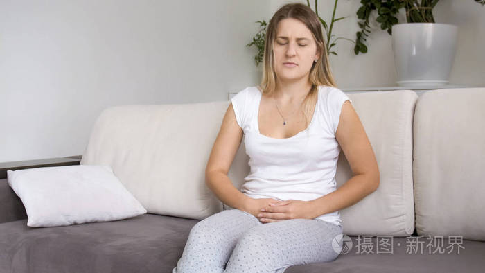 年轻妇女在腹部感到不适和痛苦
