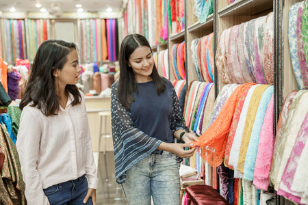 两个年轻女子 shoppic 在布料店