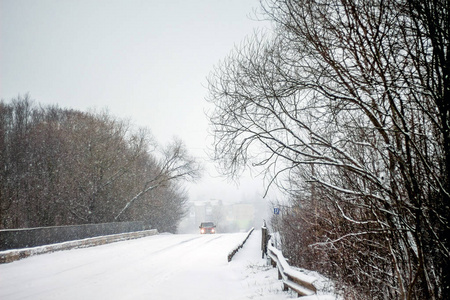 冬天的道路在树林里。道路上的汽车覆盖着积雪