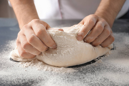 洒面粉用面粉洒在桌上的人捏面团照片