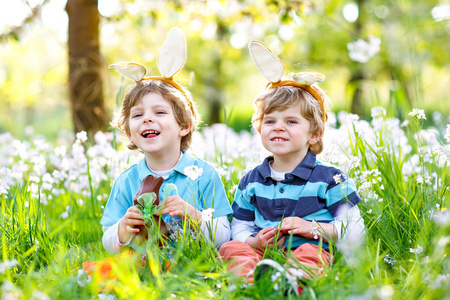 复活节兔子耳朵吃巧克力的两个小男孩朋友