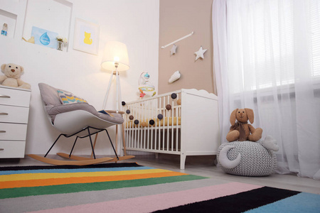 舒适的婴儿房室内配有婴儿床和摇椅