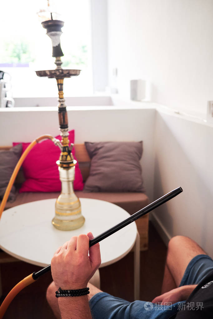 男子手拿钩管在休息室酒吧吸烟