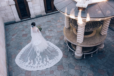 穿着白色连衣裙的新娘捧着一束美丽的结婚花束。