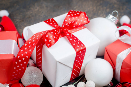 红色和白色礼品盒与丝带和节日装饰, 球和玩具在一个黑暗的背景, 圣诞贺卡, 复制 spac