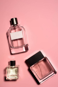 粉红色表面各种香水瓶的顶部视图