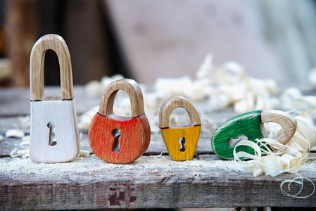 手工挂锁木制玩具。木制刨花的背景。美丽的钥匙孔在心脏形状和古典钥匙孔
