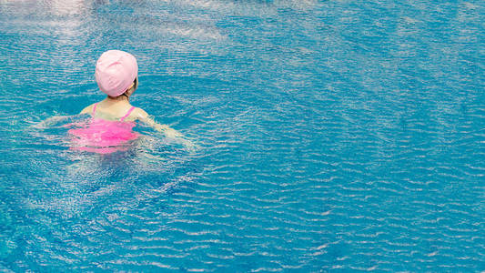 亚洲女孩在游泳池里玩耍, 很开心