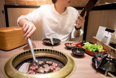 亚洲年轻人在餐厅吃韩国烧烤自助餐