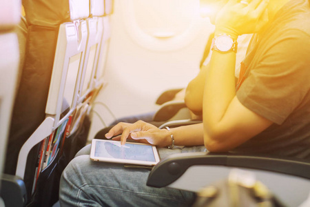 在飞机上使用数字平板电脑的男性乘客