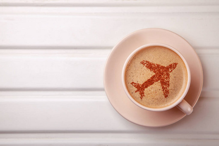 杯咖啡与飞机在泡沫。早晨的咖啡在飞行中