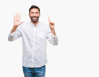 成年西班牙裔男子在孤立的背景显示和指向手指数六, 而微笑着自信和快乐