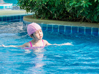 亚洲女孩在游泳池里玩耍, 阳光明媚
