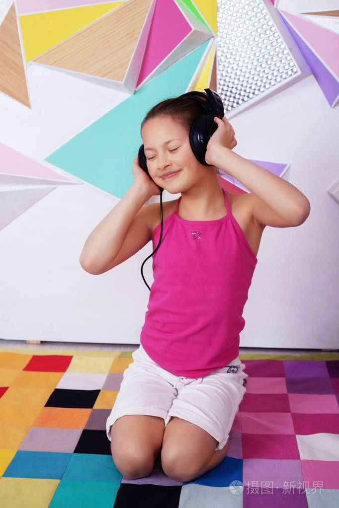 美丽快乐的儿童女孩通过耳机听音乐.童年与音乐的概念