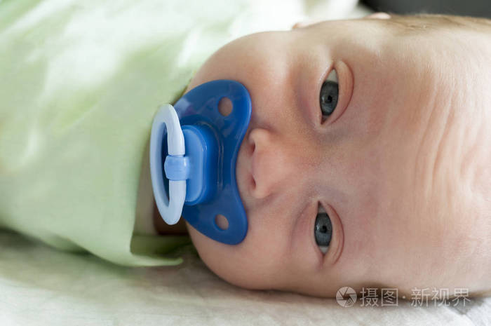 一个婴儿小男孩吸奶嘴.这个孩子是钩编的