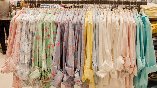 零售商店的衣架上有五颜六色的女式衬衫。时尚与购物理念